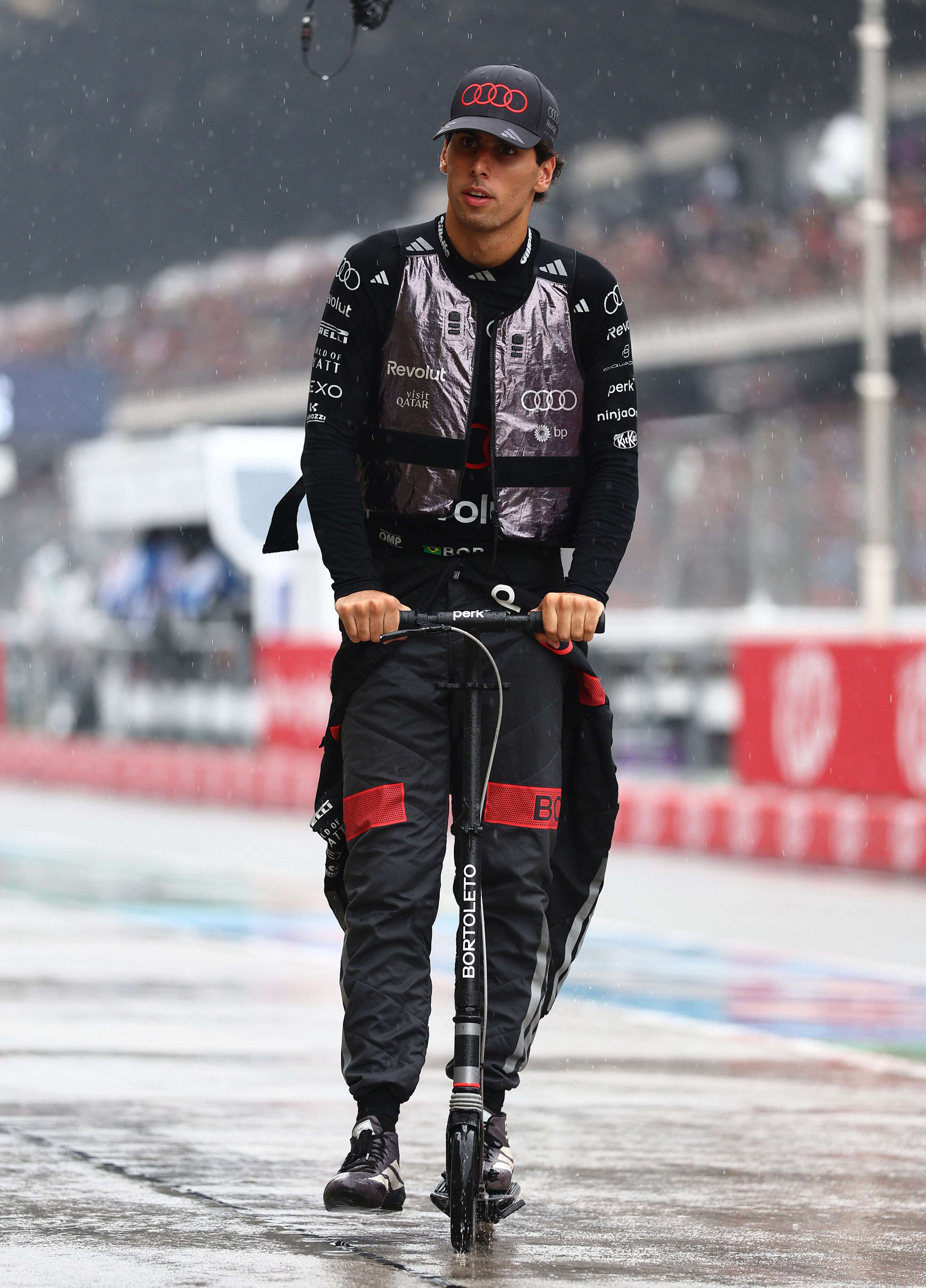 F1 Grand Prix of Bahrain in Malaysia - KUALA LUMPUR, MALAYSIA - OCTOBER 04: Gabriel Bortoleto of Brazil and Audi F1 Team on a scooter in the wet pitlane prior to the F1 Grand Prix of Bahrain in Malaysia at Sepang Circuit on October 04, 2026 in Kuala Lumpur,...